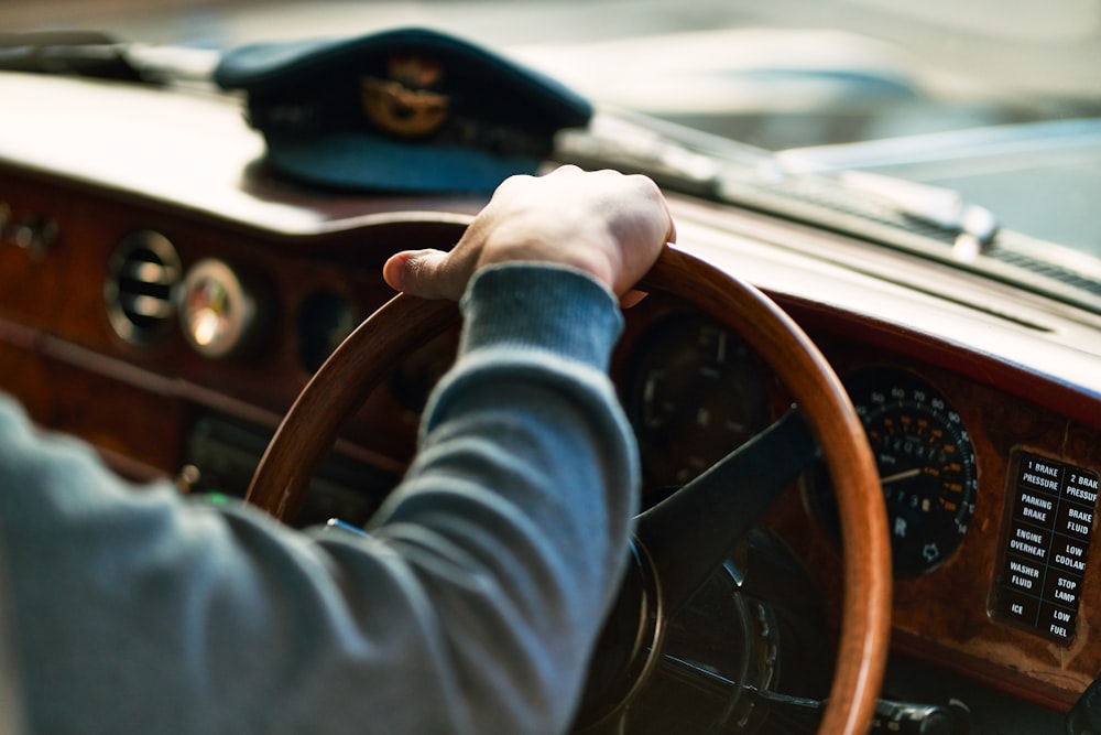 a person driving a car with a steering wheel