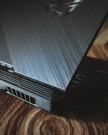 a laptop computer sitting on top of a wooden table
