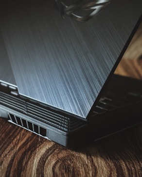 a laptop computer sitting on top of a wooden table