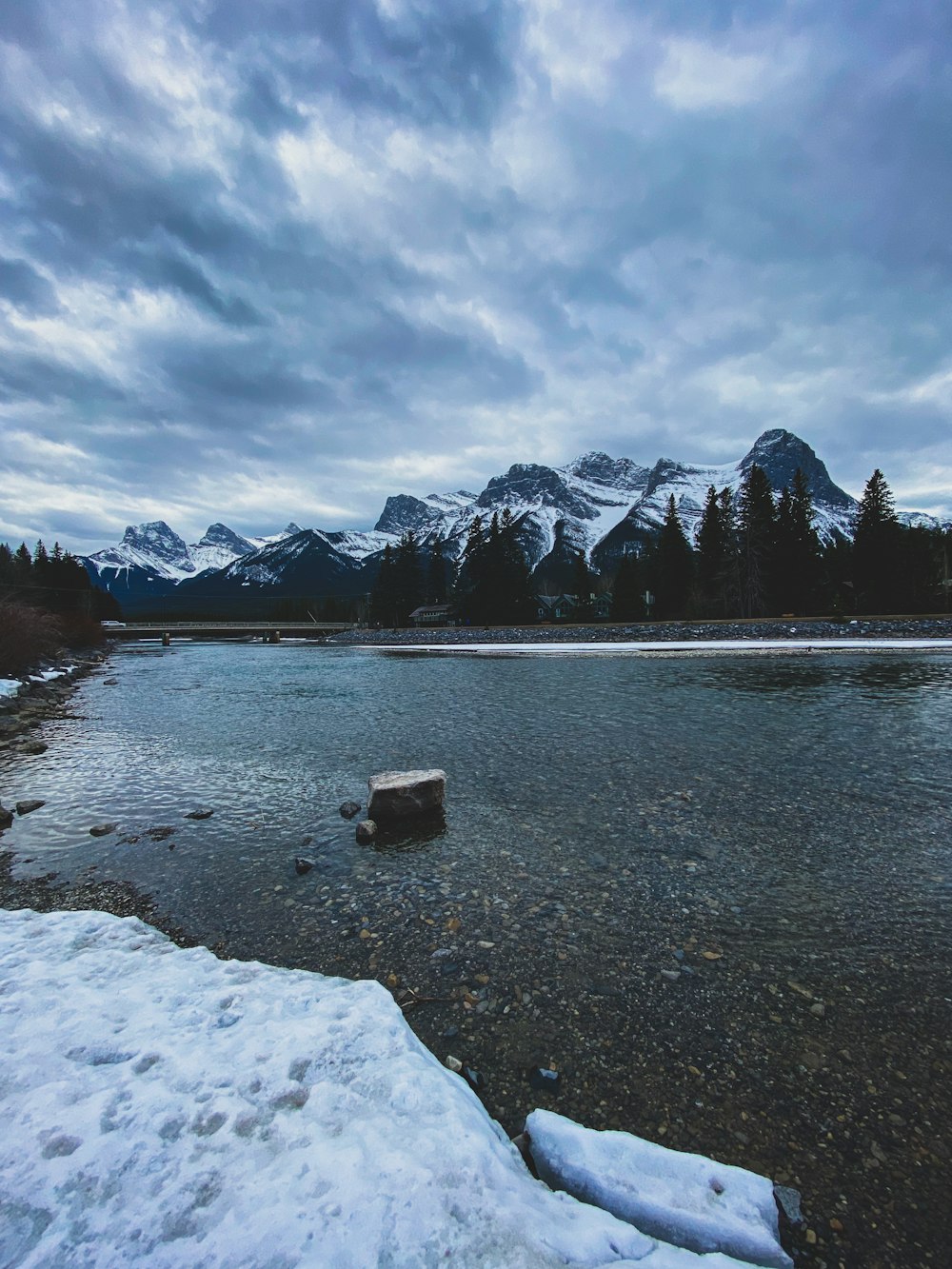 a body of water surrounded by snow covered mountains