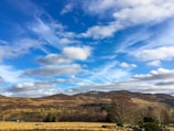 A serene landscape with rolling hills under a blue sky.