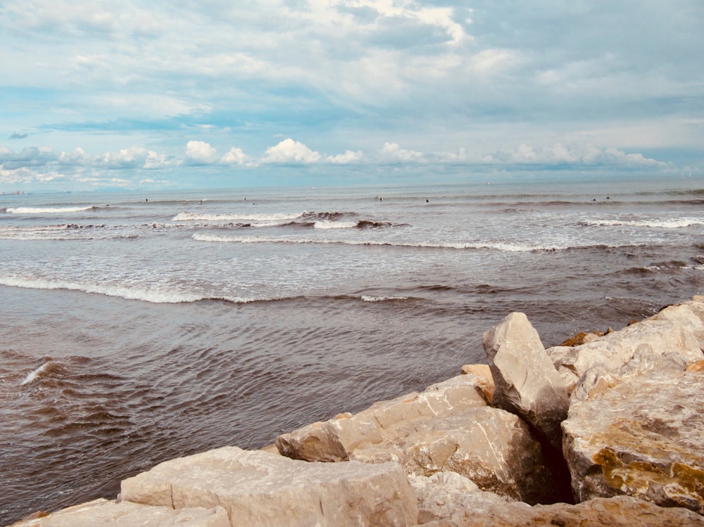 a view of a body of water with rocks in the foreground