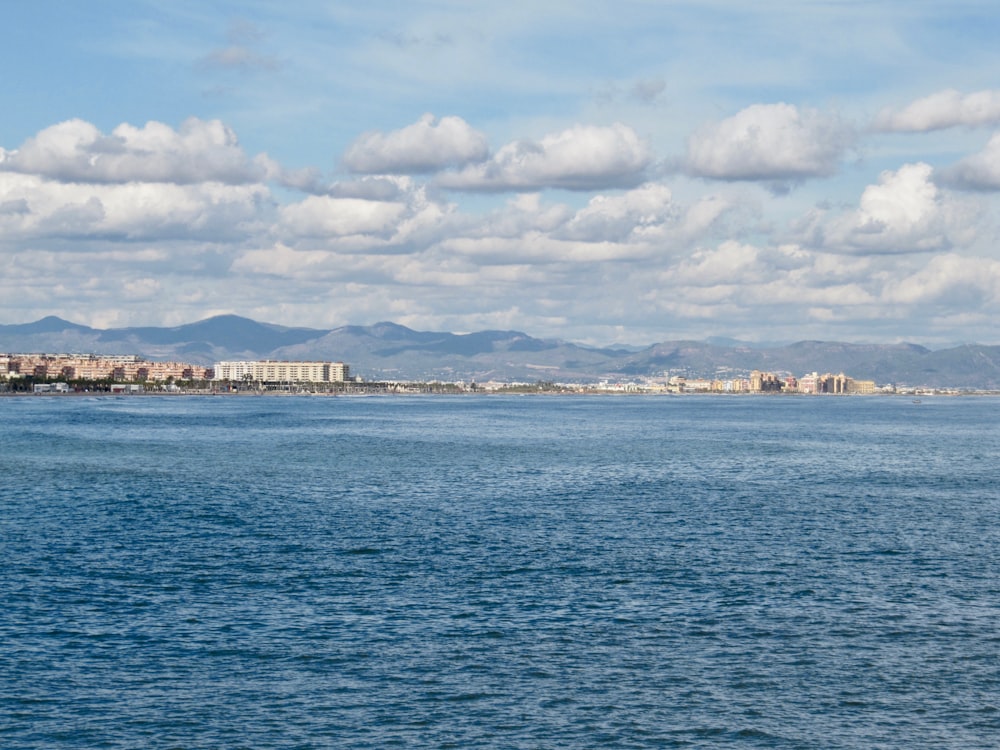 a large body of water with a city in the background