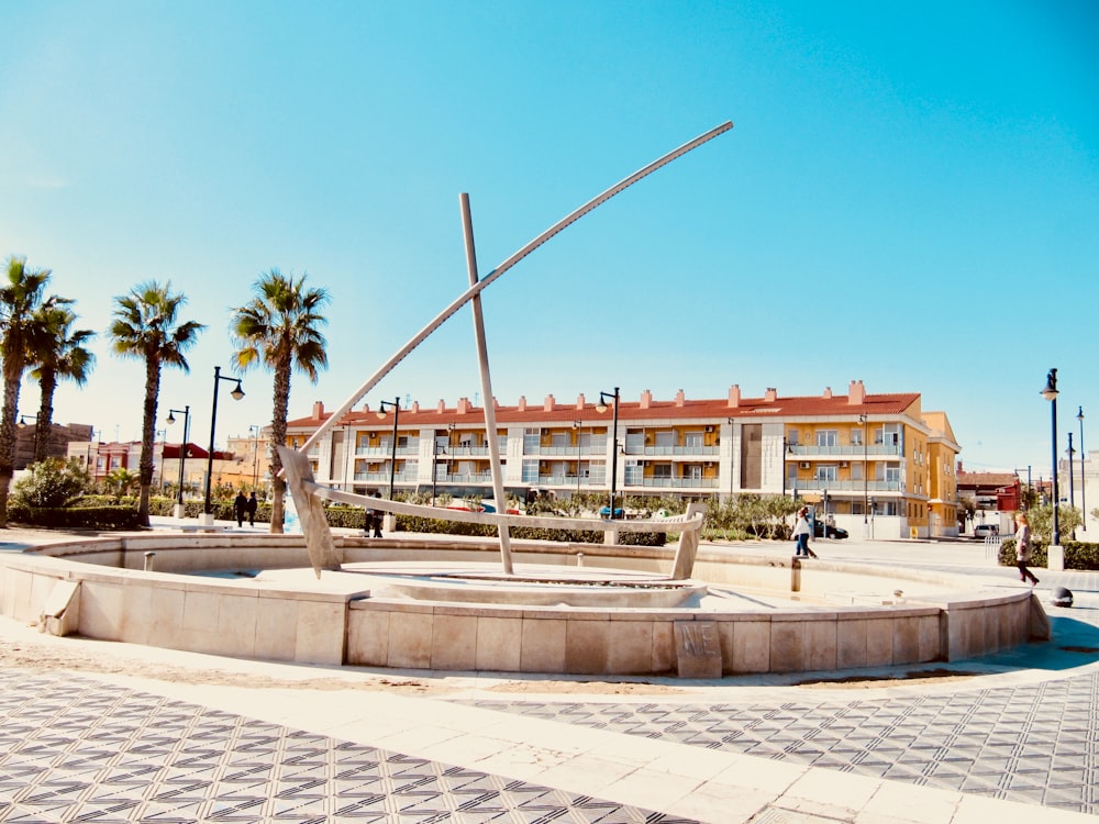 a statue of a boat in a plaza in front of a hotel