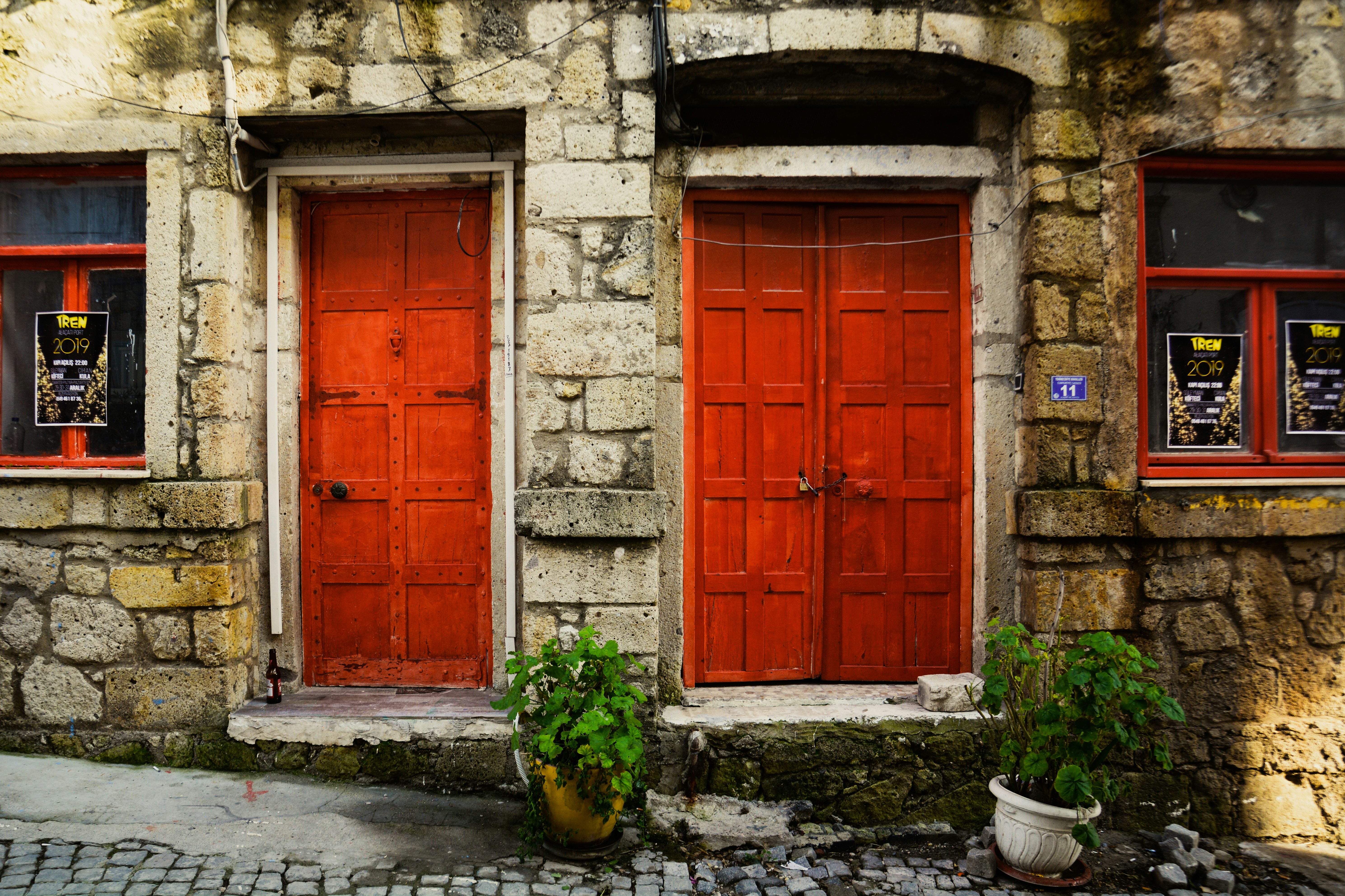 a couple of red doors sitting on the side of a building