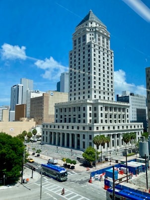 a large white building with a blue bus in front of it