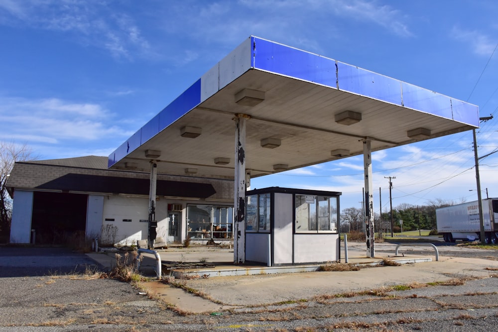 an old gas station with a blue roof