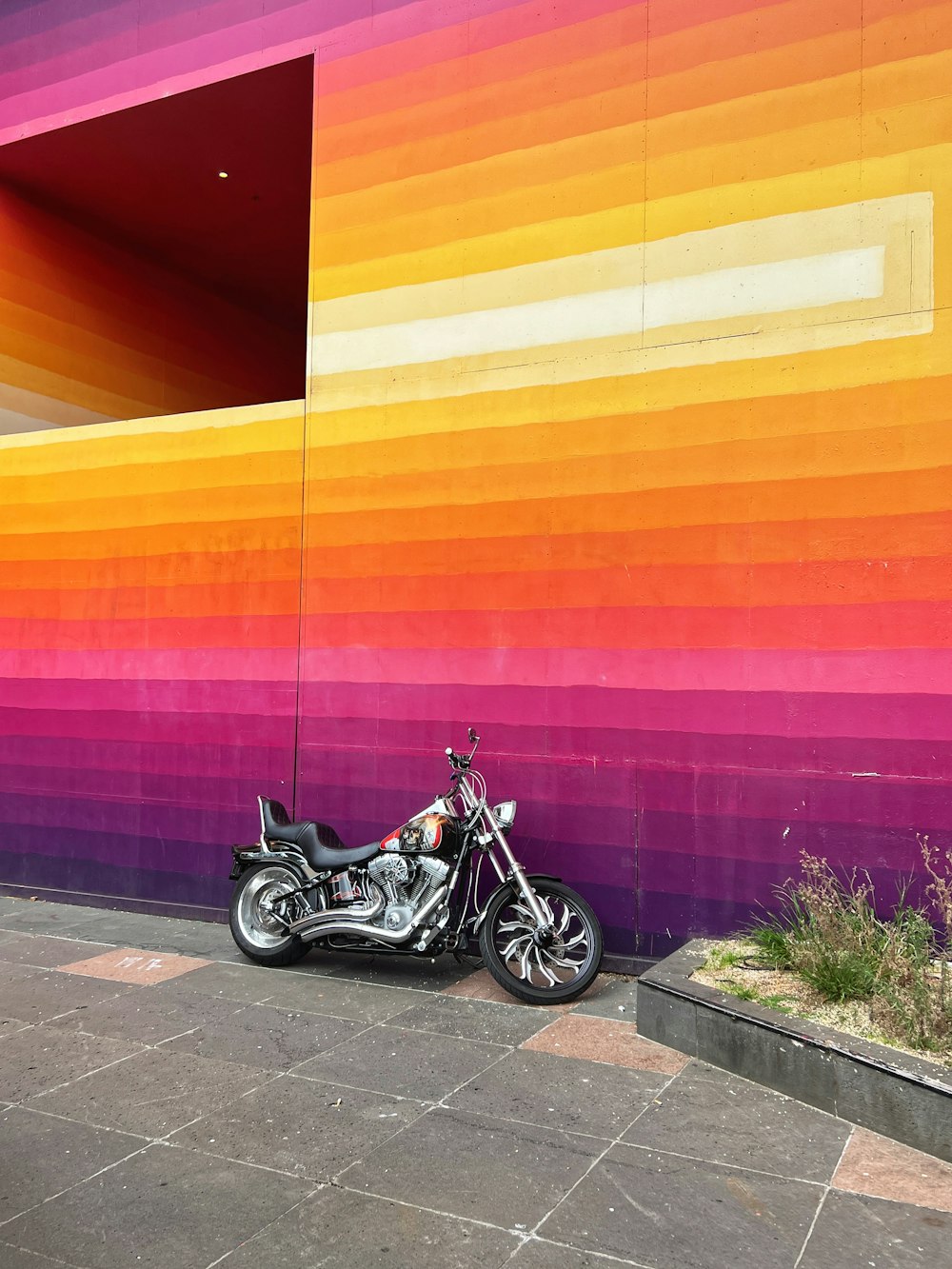 a motorcycle parked in front of a colorful wall