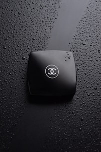 A waterproof travel pouch holding toiletries, with water droplets on the surface to highlight its moisture resistance.