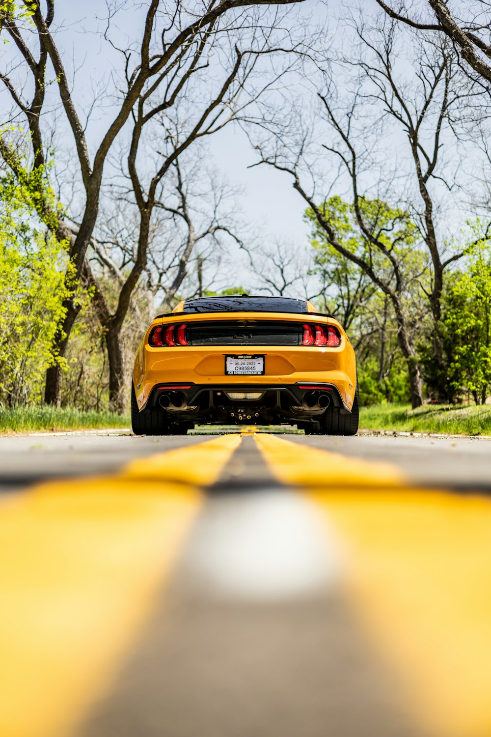 Un coche deportivo amarillo estacionado al costado de la carretera