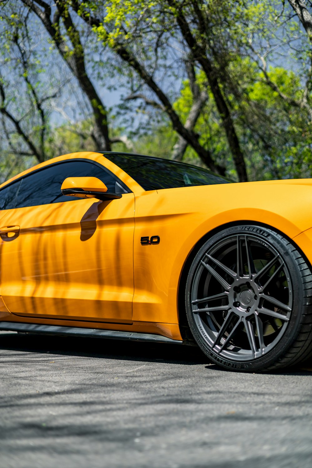 a yellow sports car parked on the side of the road