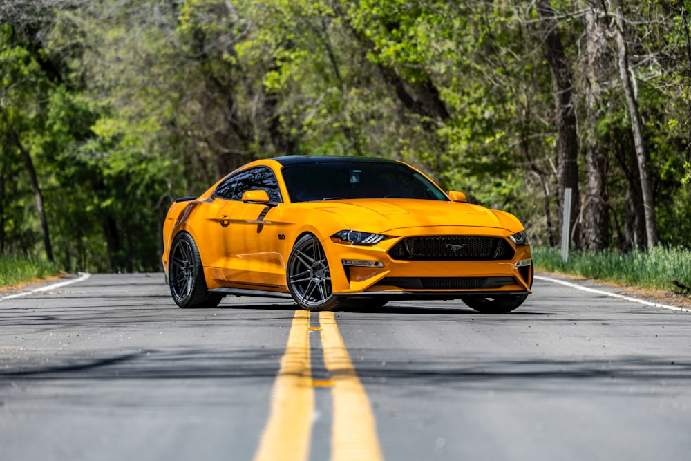 a yellow ford mustang parked on the side of the road