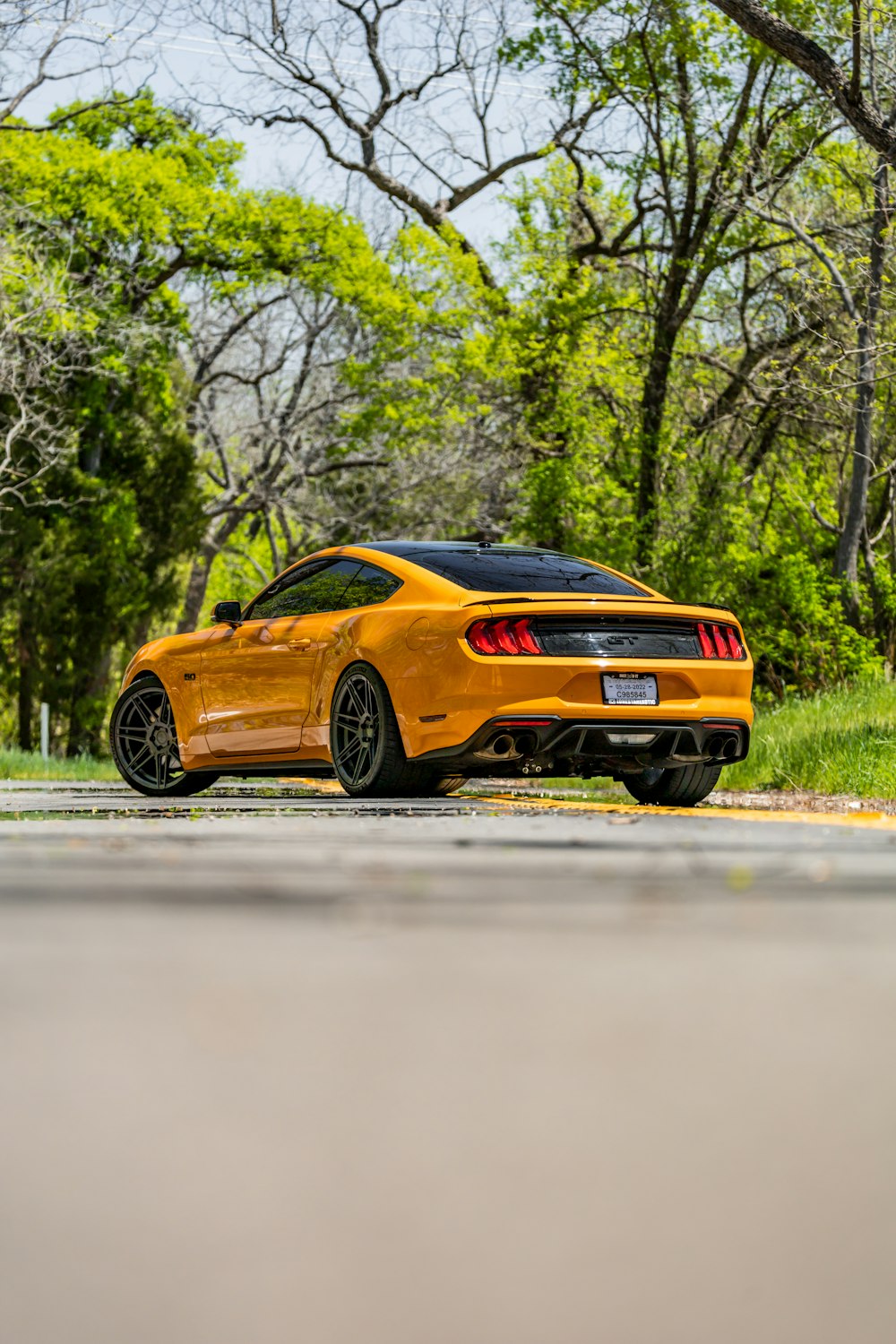 a yellow sports car parked on the side of the road