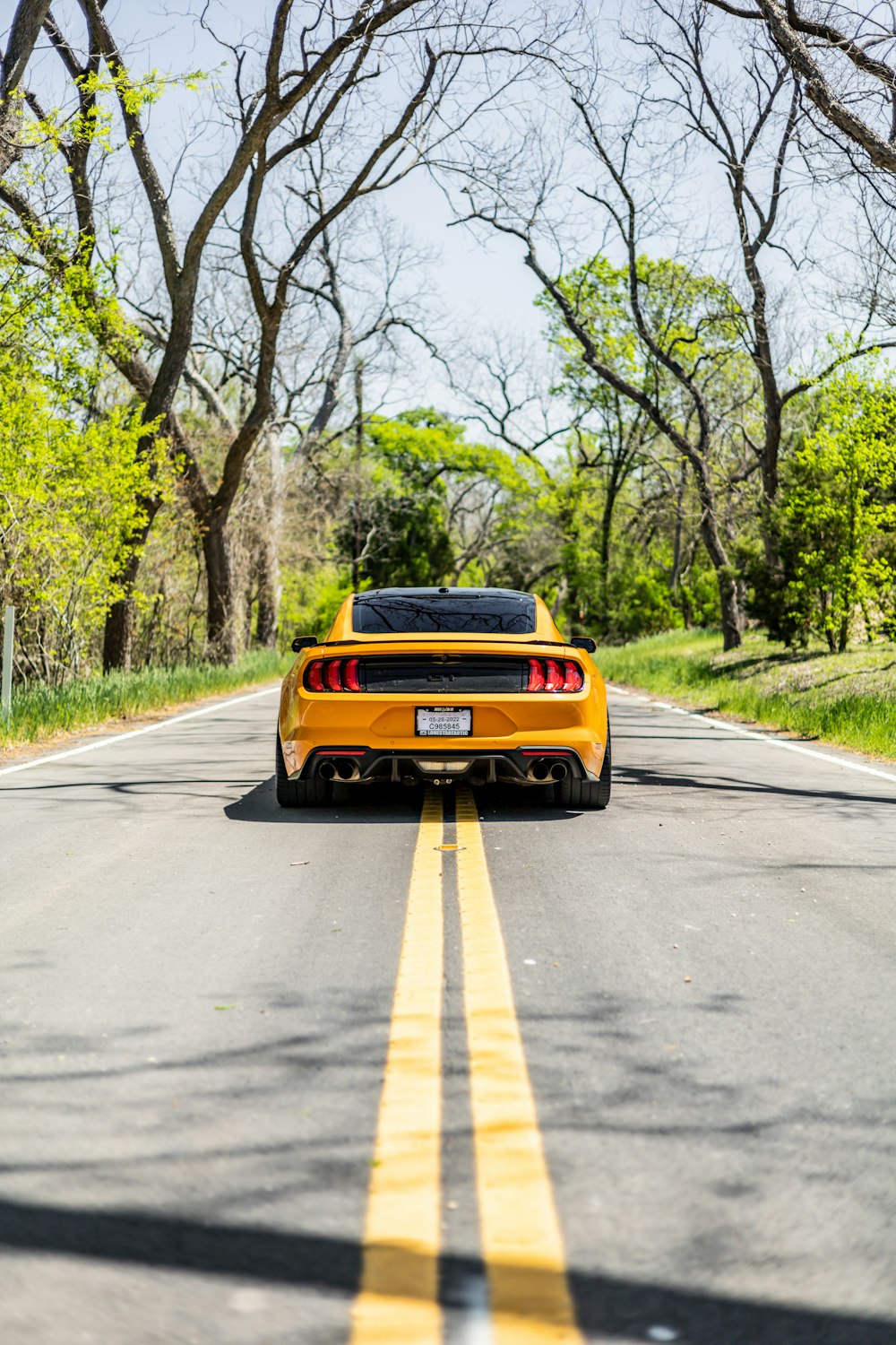 a yellow sports car parked on the side of the road