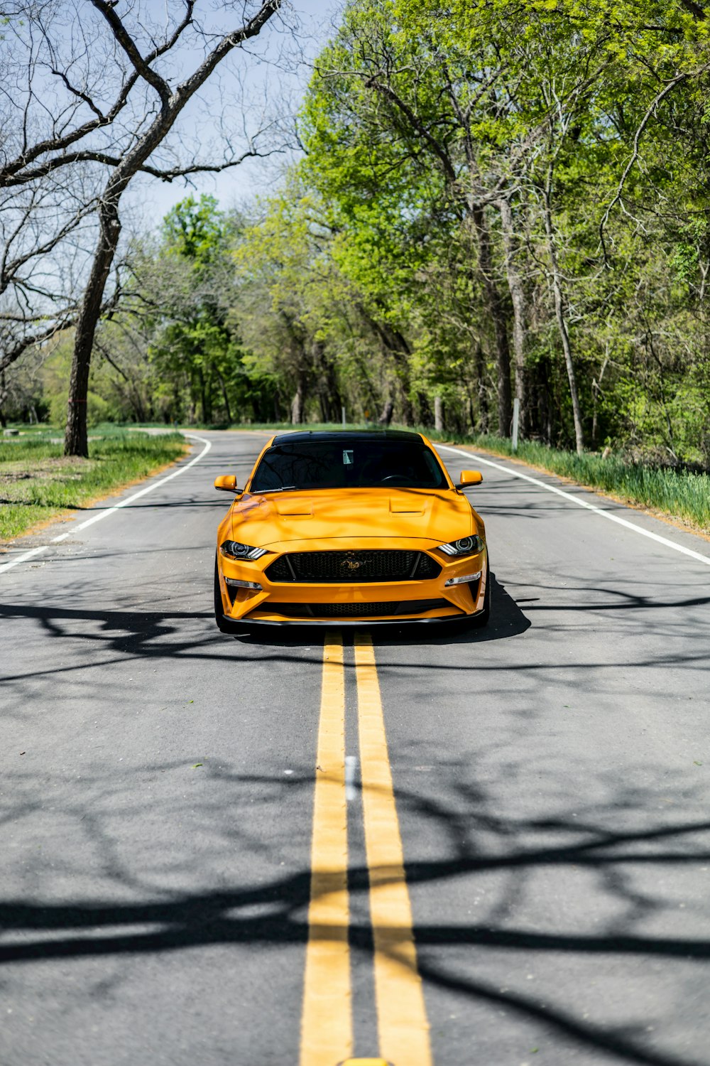 Un auto deportivo amarillo está conduciendo por la carretera