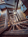 Warm wooden staircase lit by a vintage lantern, showcasing cottage charm.