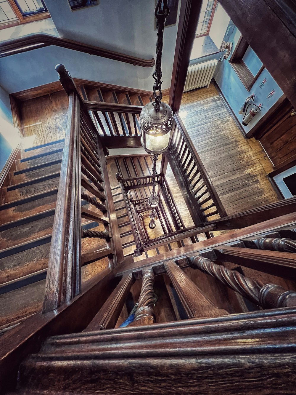 a wooden staircase with a chandelier hanging from the ceiling