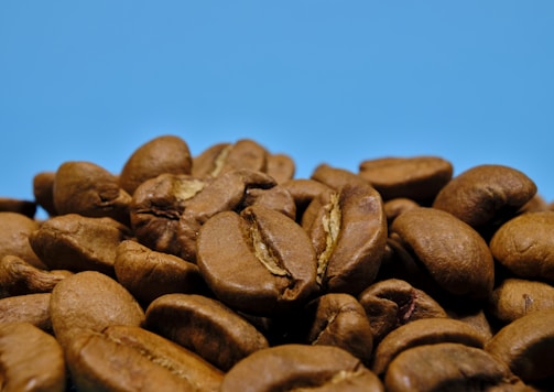 a pile of roasted coffee beans against a blue background