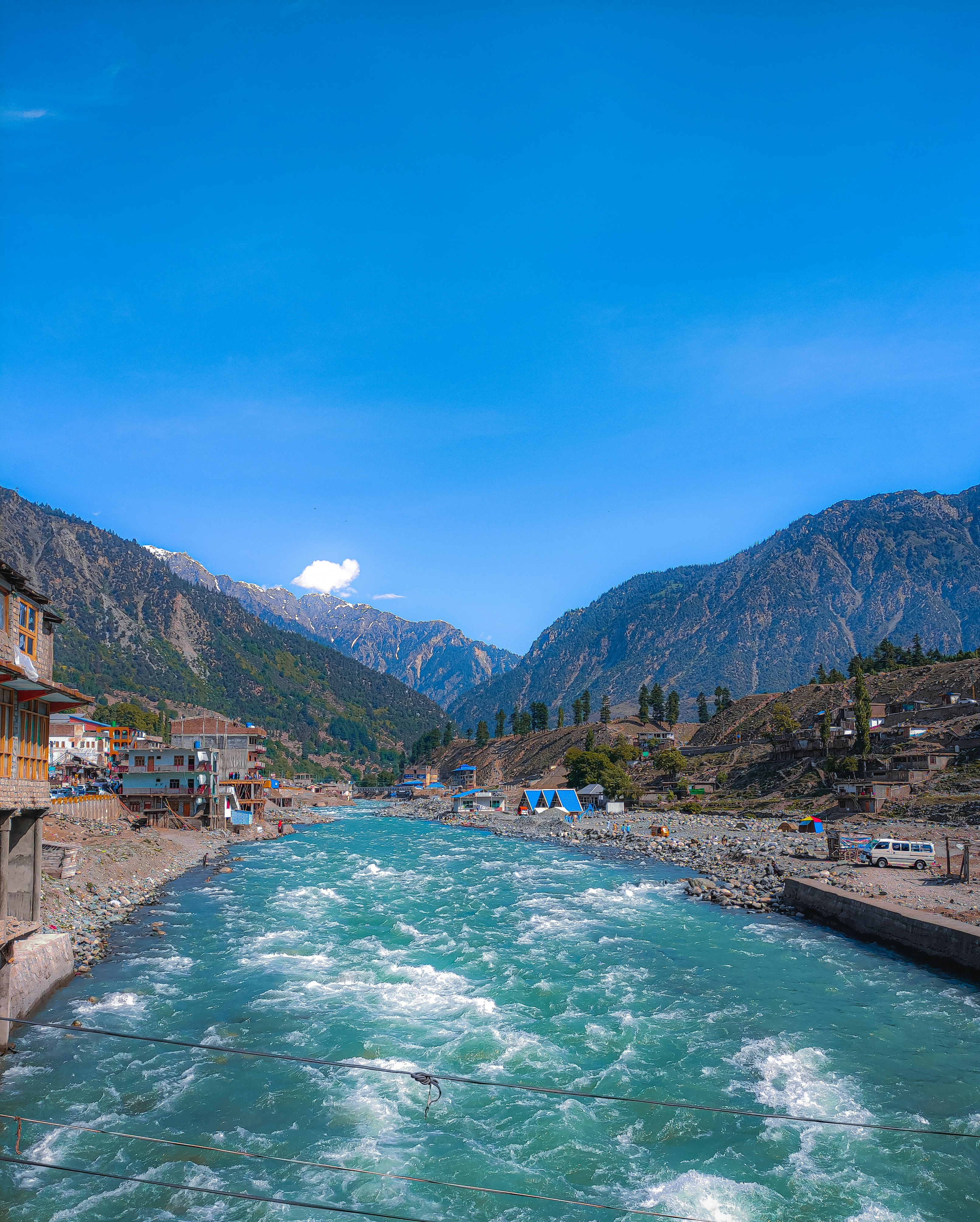 a river running through a town surrounded by mountains