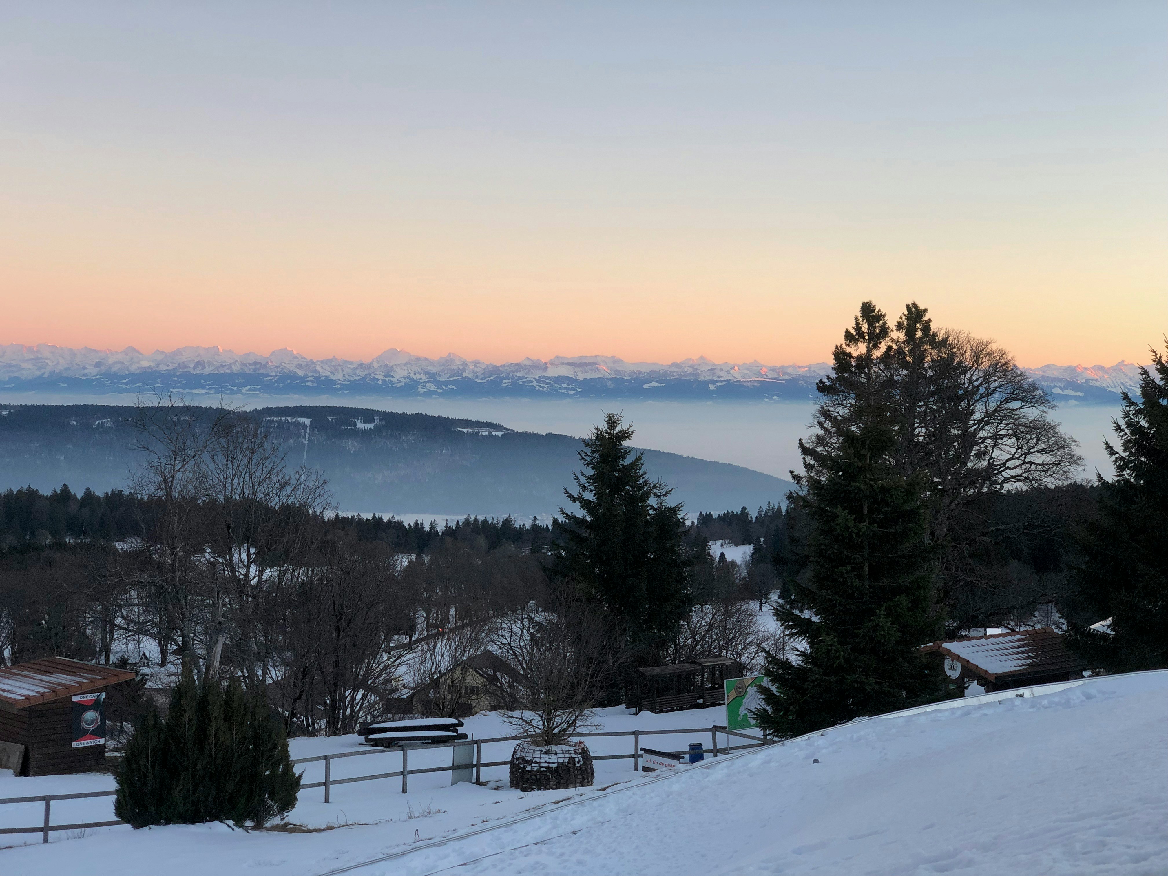 une vue d’une chaîne de montagnes enneigée au coucher du soleil