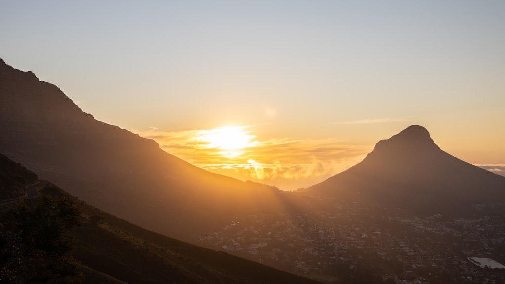 the sun is setting over a mountain range