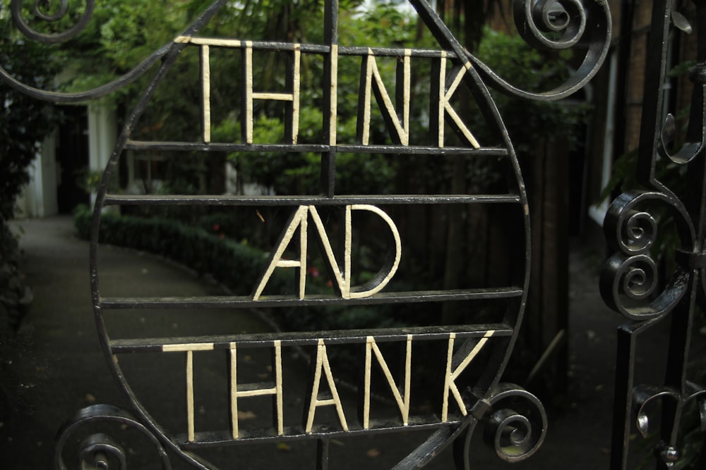 Ein Schild mit der Aufschrift "Think and Thank on a Gate"