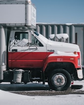 a red and white truck parked in front of a building