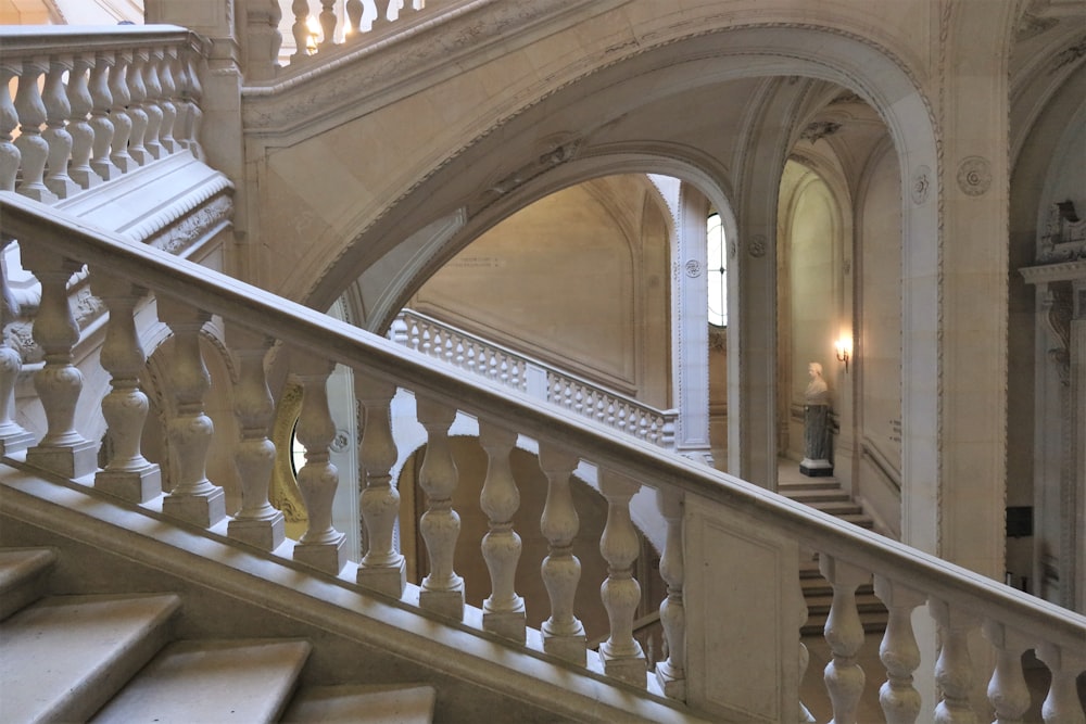 eine Treppe in einem großen Gebäude mit weißen Geländern