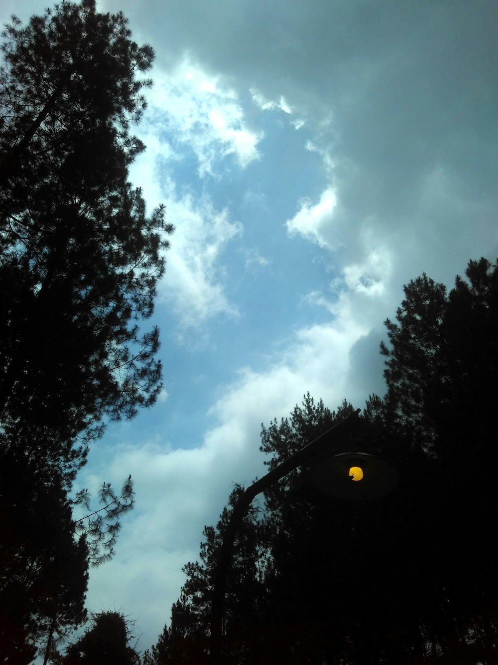 a street light in front of a cloudy sky