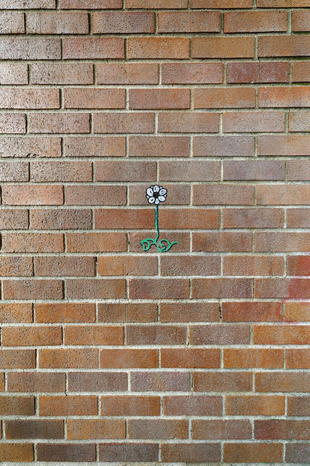 a red fire hydrant sitting on the side of a brick wall