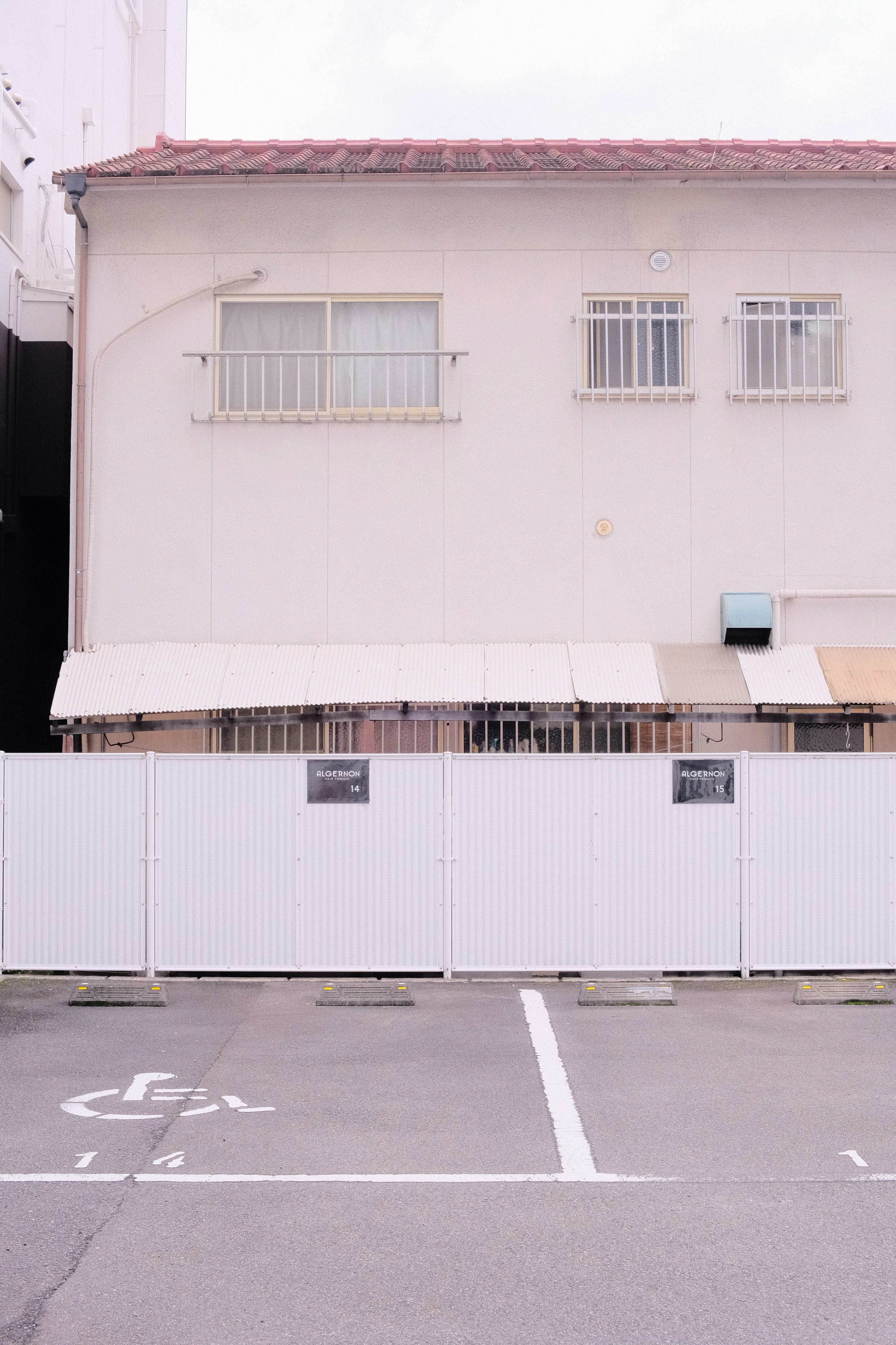 an empty parking lot in front of a white building