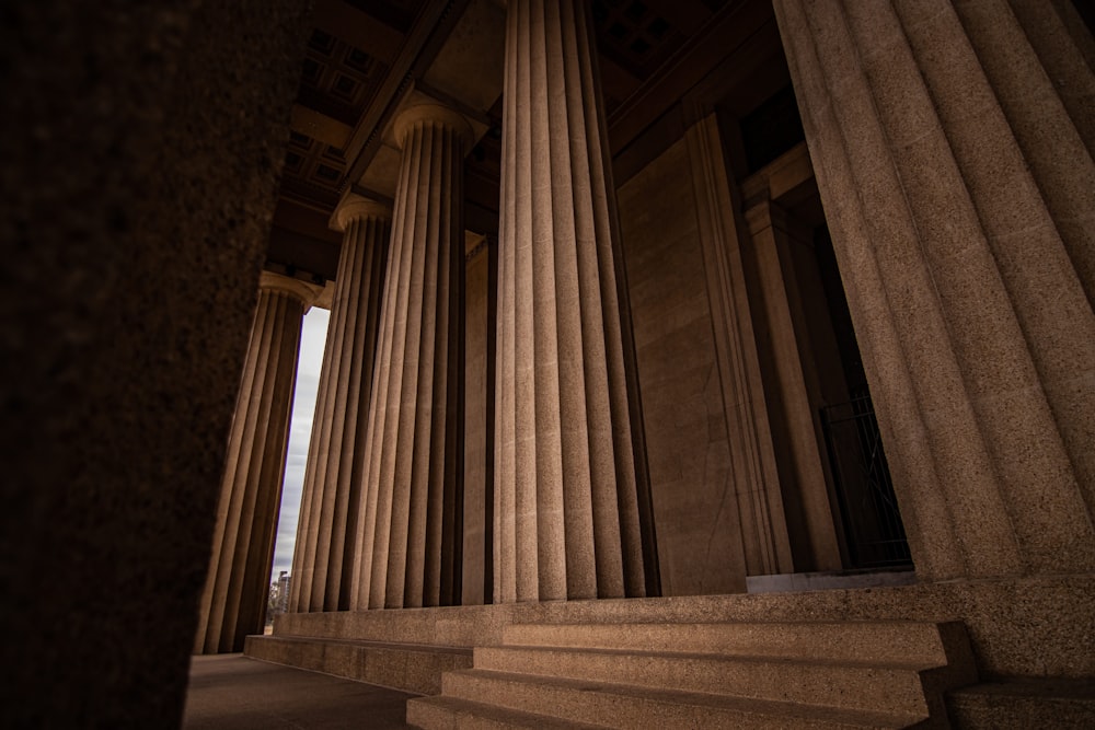 the columns of a building with a sky in the background