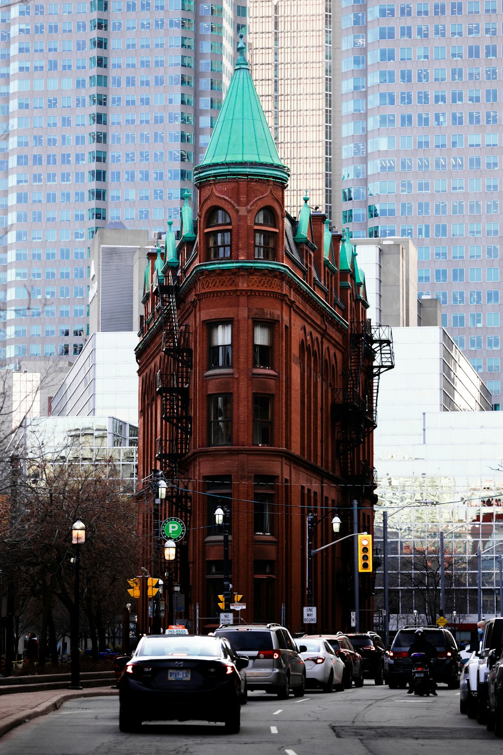 a tall building with a green top on a city street