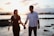 A happy couple walking hand-in-hand along a picturesque beach at sunset.