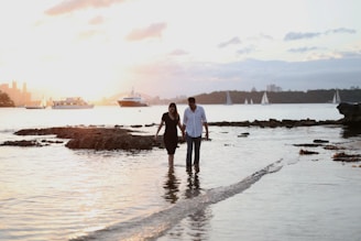 a man and a woman are walking in the water