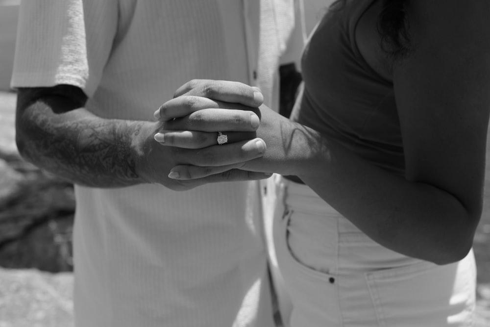 a man and a woman holding hands while standing next to each other