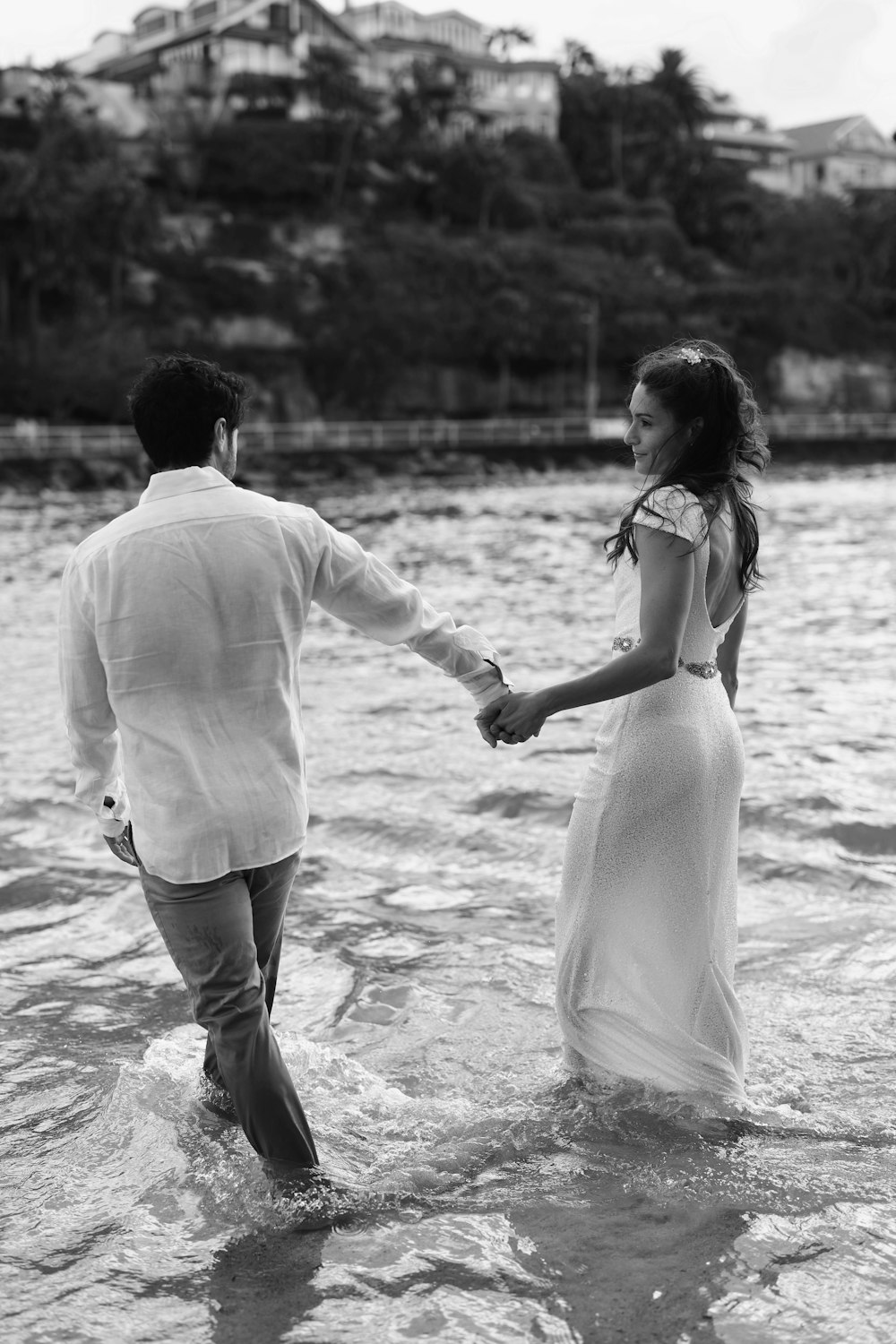 a man and a woman holding hands in the water