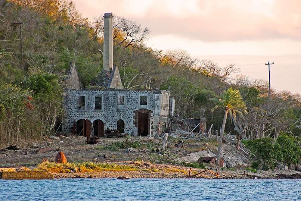 an old stone building sitting on top of a lush green hillside