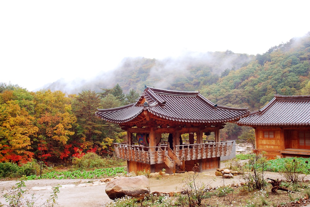 a building with a balcony in the middle of a forest