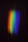 a rainbow of light shining on a black background