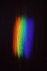 a rainbow of light shining on a black background