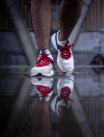 Close-up of a runner's feet pounding the pavement, with black, white, and red shoes reflecting the club's colors.