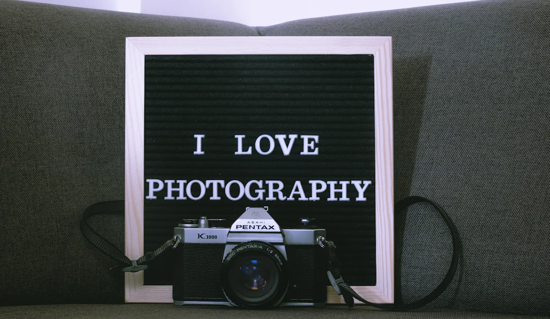 a picture frame sitting on top of a couch next to a camera