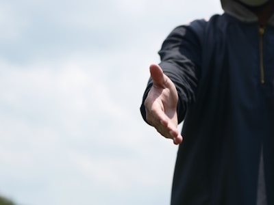 a man in a hoodie holding out his hand