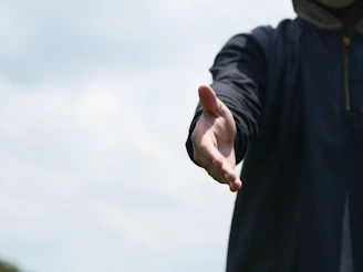 a man in a hoodie holding out his hand