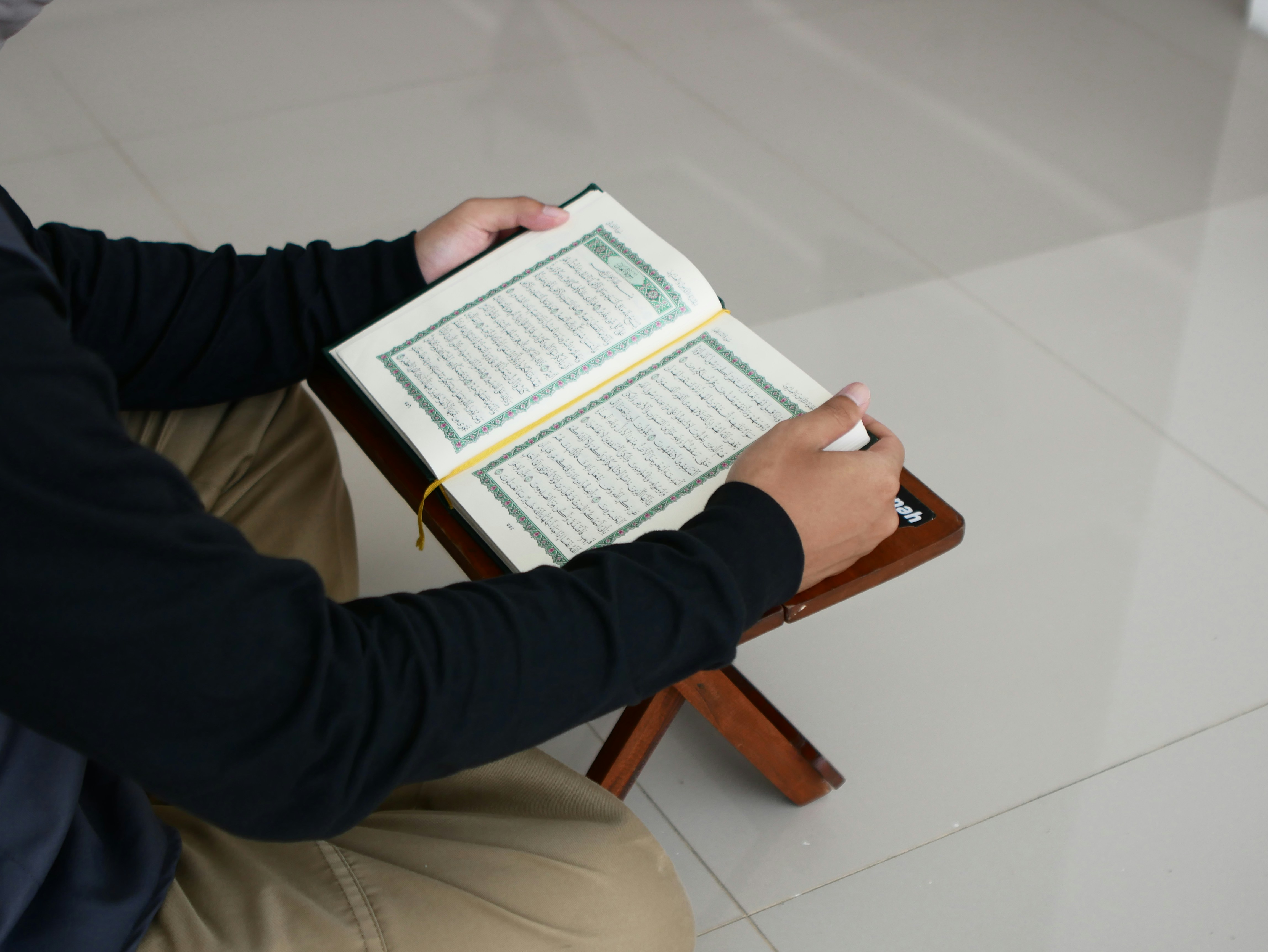 A person studying the Quran with a digital tablet