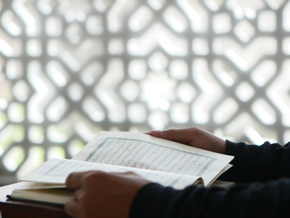 a person sitting at a table with a book