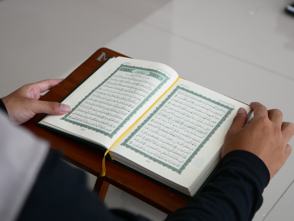 a person sitting at a table with an open book