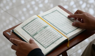 a person sitting at a table with an open book