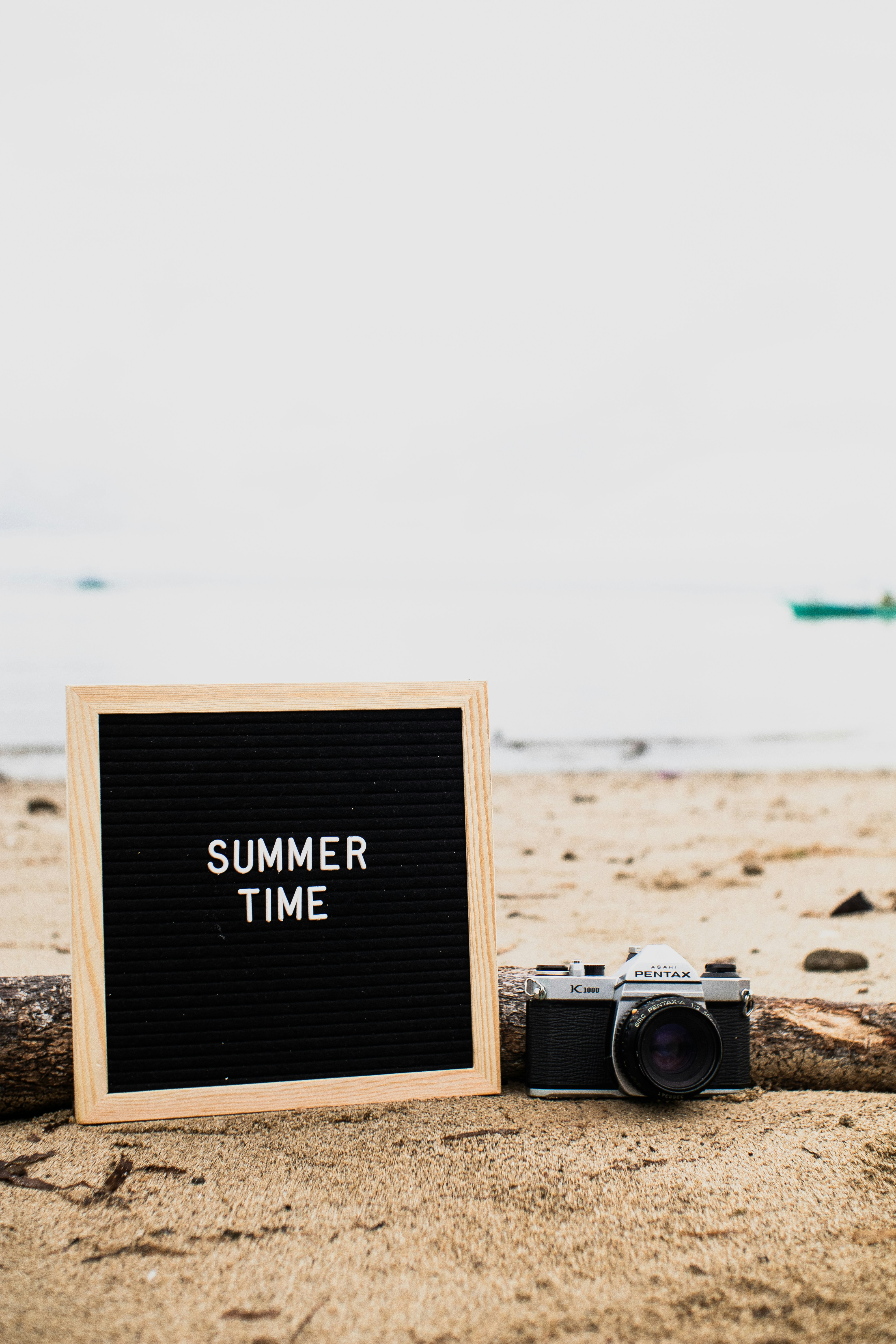 a sign that says summer time next to a camera
